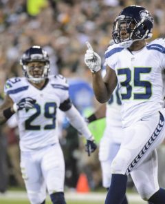 DeShawn Shead celebrates a tackle for loss with teammates Bobby Wagner and Earl Thomas.